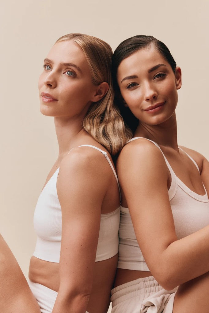 Two women sitting back-to-back
